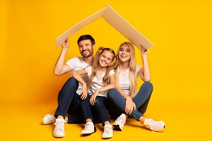 family sitting under cardboard roof